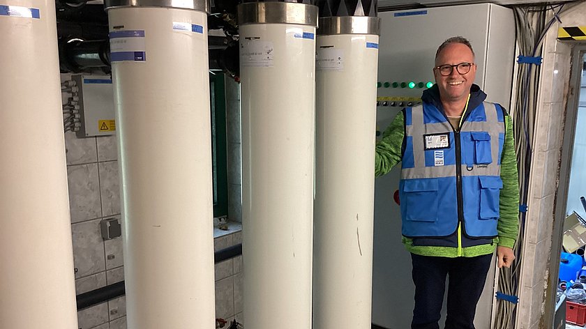 Mann steht neben Säulen