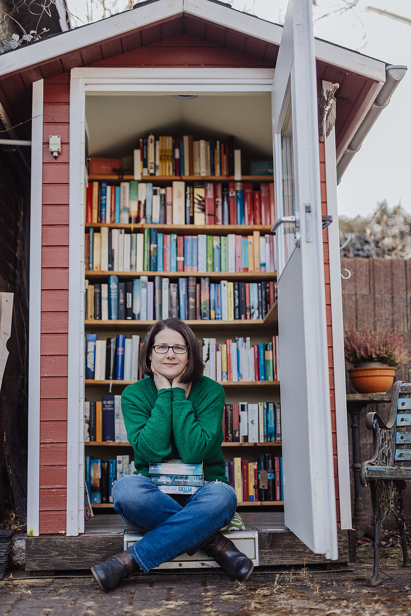 Frau vor Bücherschrank