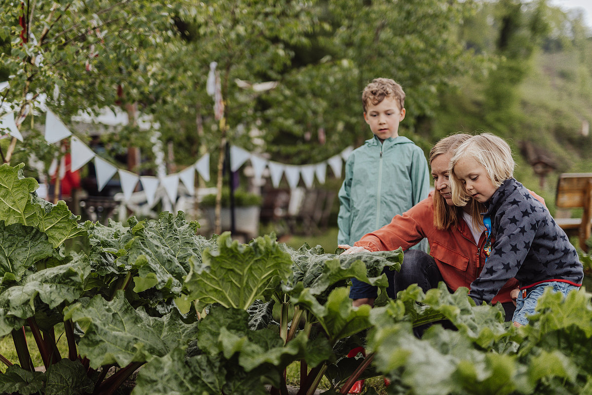 Kinder und Frau im Garten