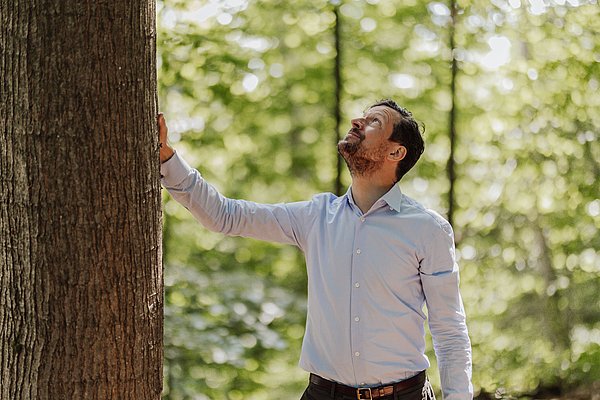 Mann neben Baum
